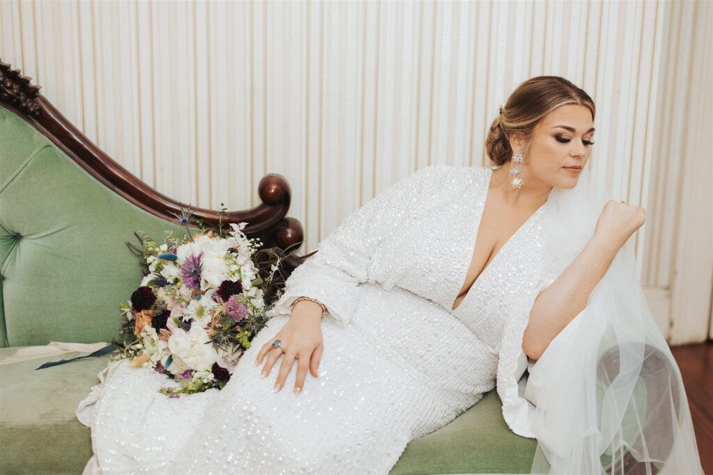 bride getting ready on green sofa at the Ezell House in Downtown Mobile Alabama