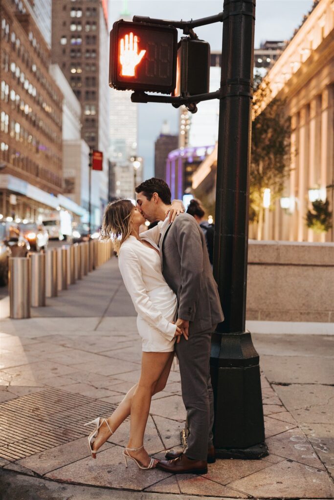 engaged couple kissing on the street in new york city