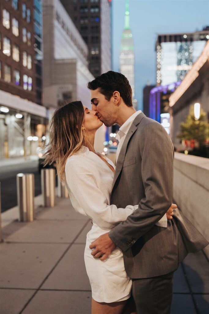 engaged couple kissing on the street in new york city