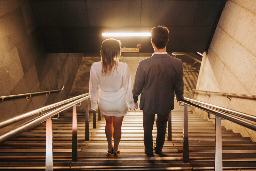 engaged couple walking down the steps to a subway in new york city