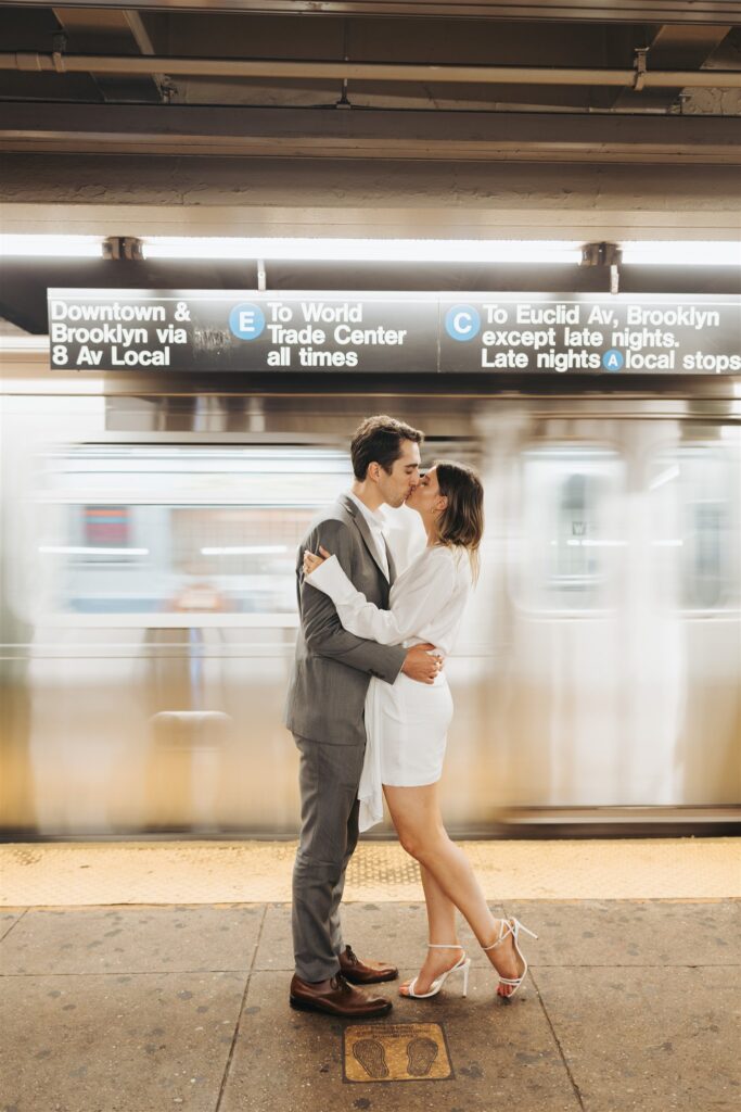 engaged couple kissing in front of a subway in new york city