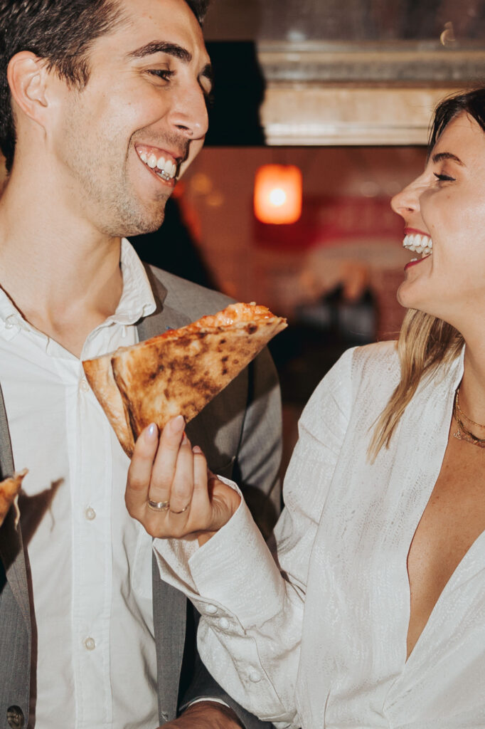 engaged couple eating pizza at pizza shop in new york city