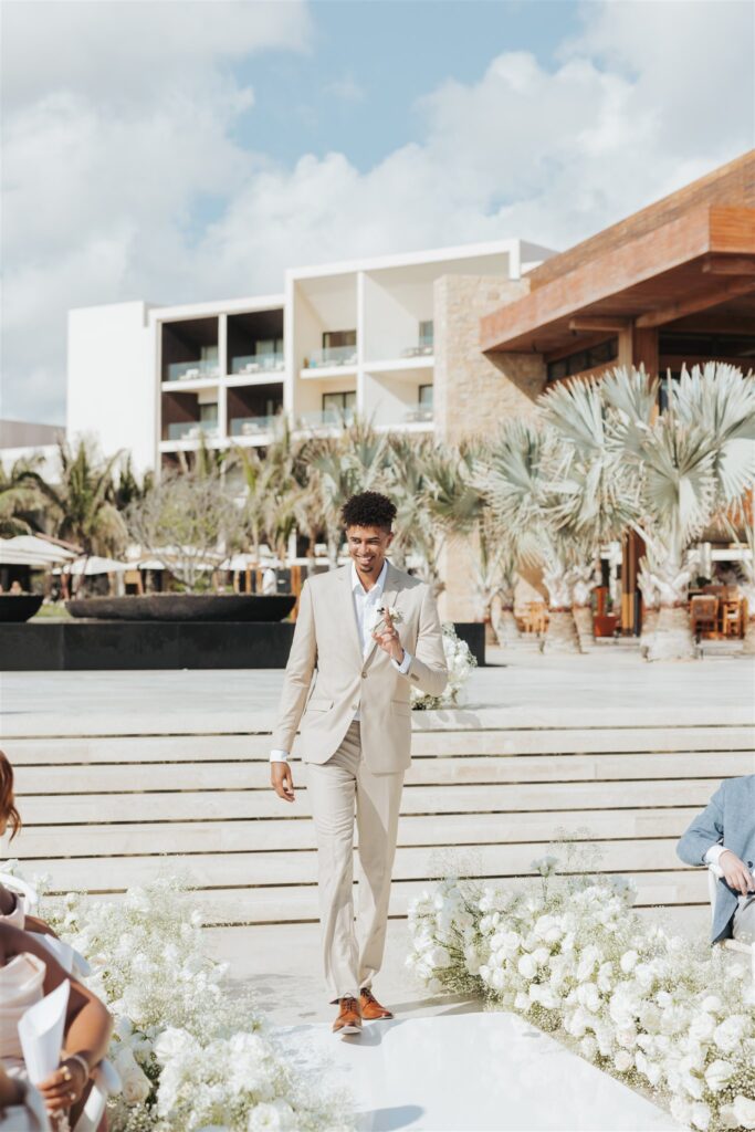 groom walking down the aisle for beach wedding in los cabos