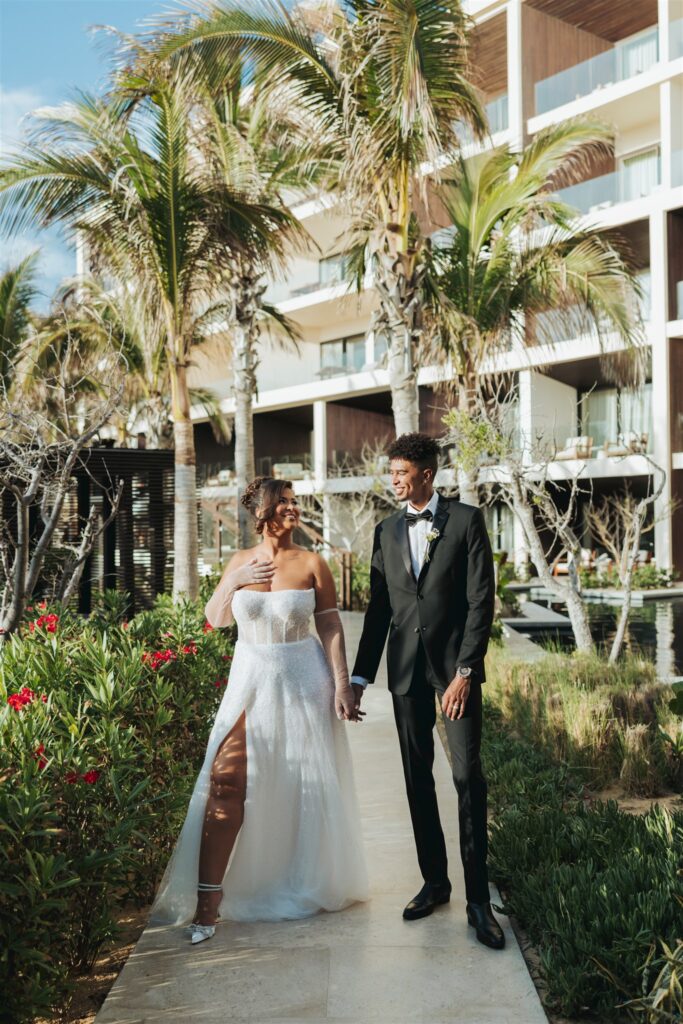 bride and groom in front of hotel at the beach