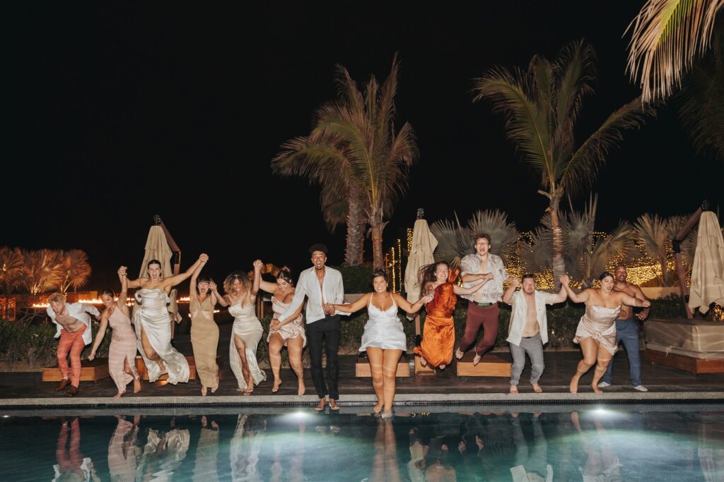 bride and groom and wedding party jumping in the pool after wedding reception