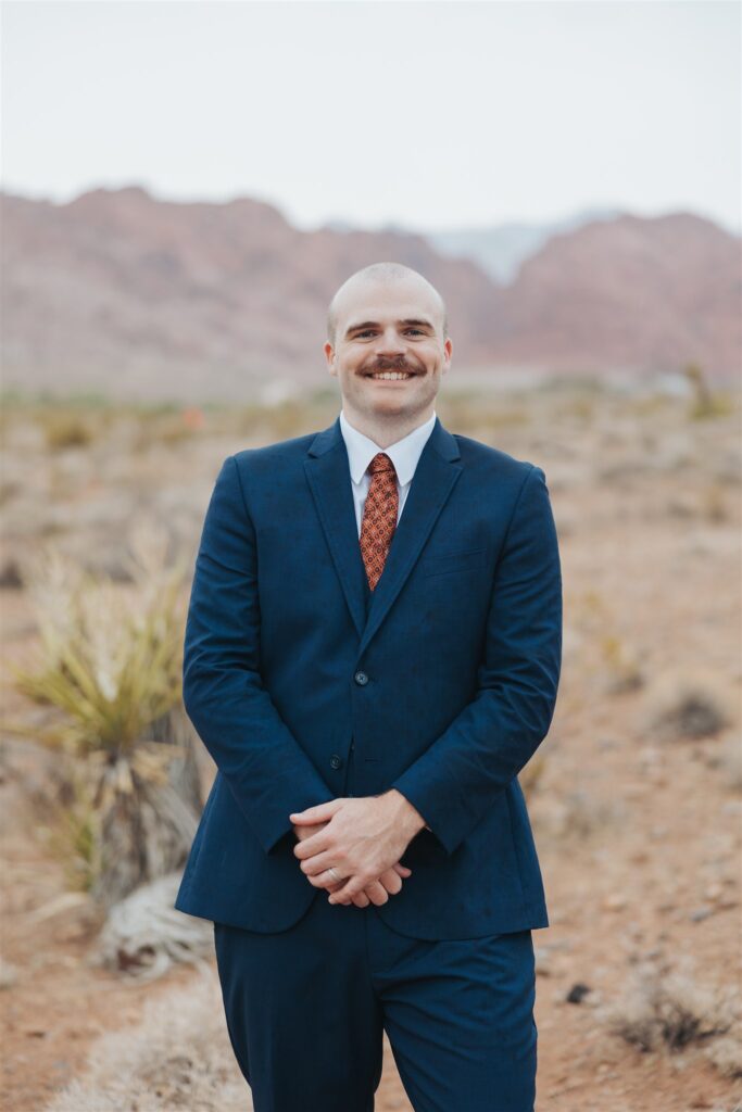 groom portraits in the dessert in front of red rock