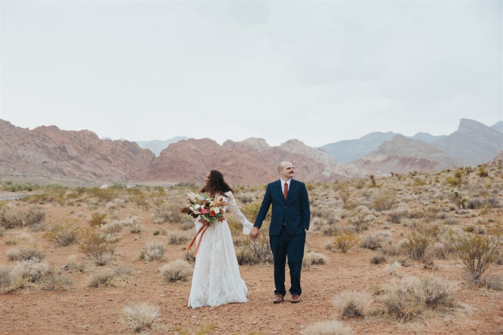 bride and groom portraits in the dessert in front of red rock