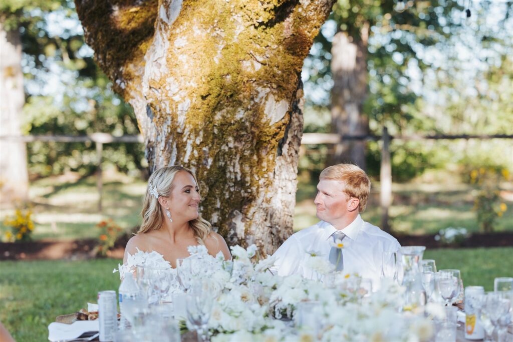 bride and groom at reception table at garden party wedding in aurora, oregon