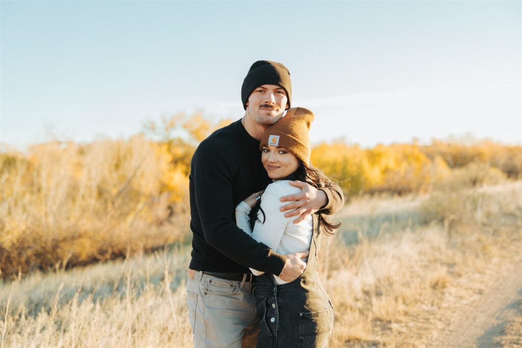 couple hugging in a field in the fall in colorado