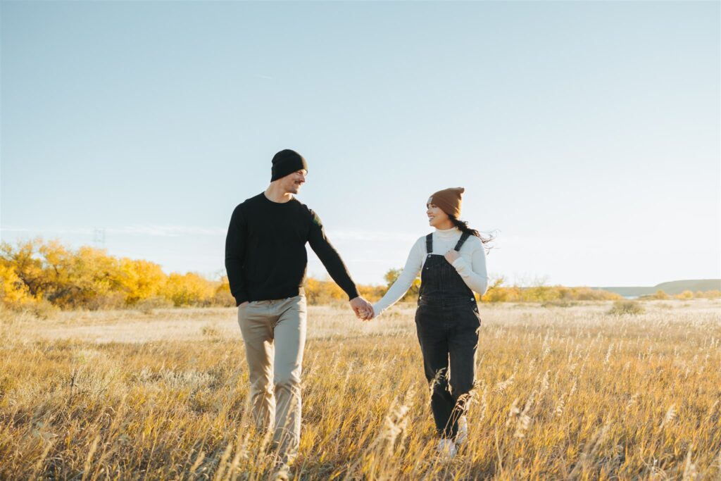 couple walking in a field in the fall in colorado
