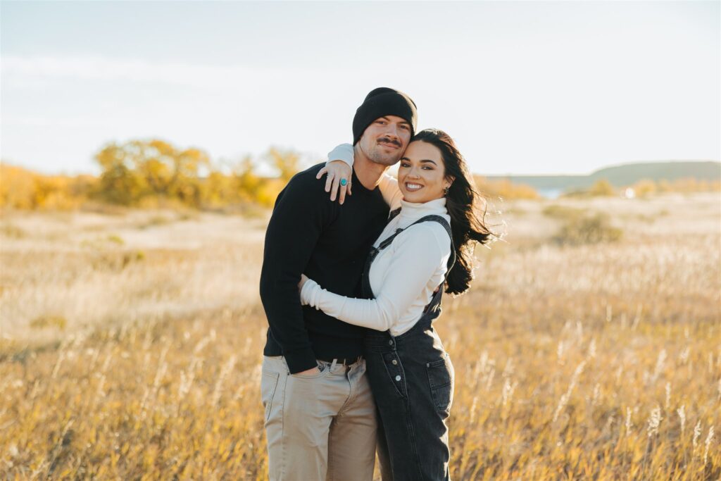 couple sitting in a field in the fall