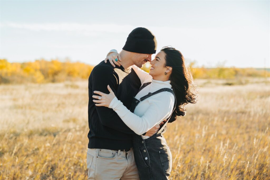 couple hugging in a field in the fall