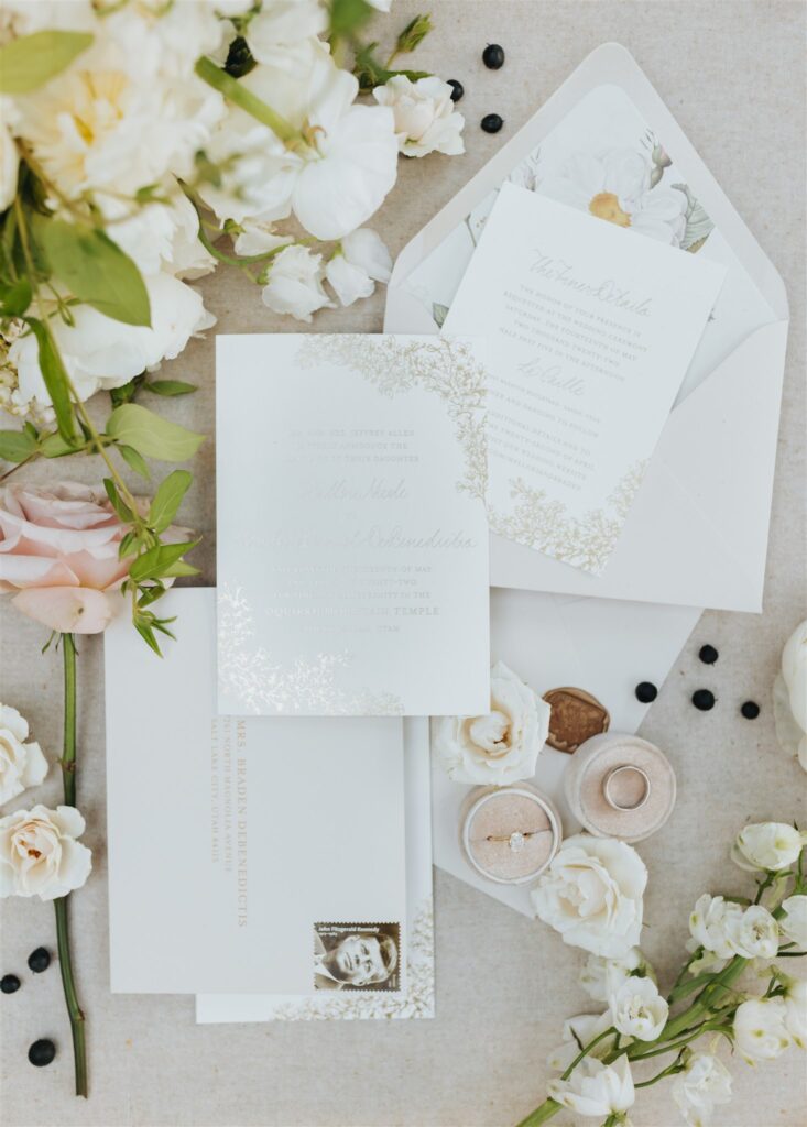 pink and white wedding details with stationary and wedding rings
